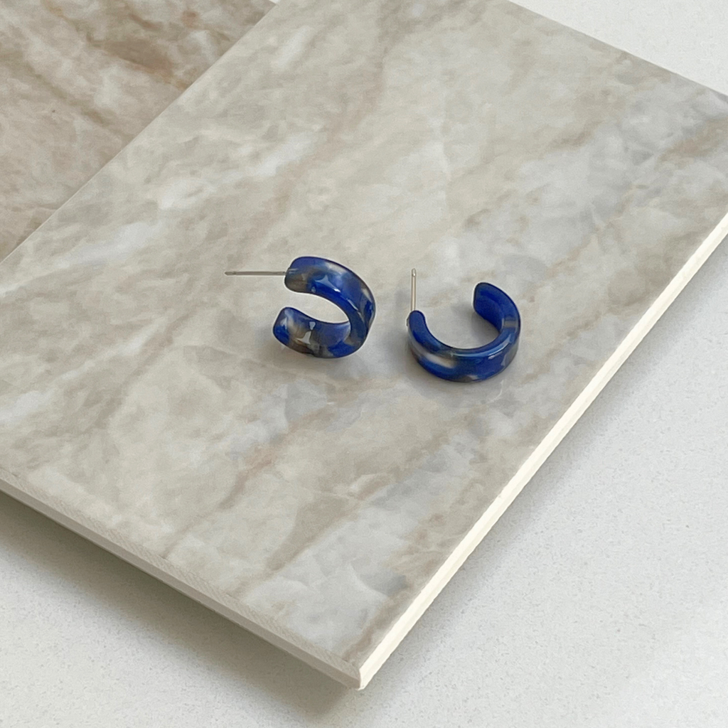 Blue Tortoiseshell Mini Hoop Earrings on a marble top