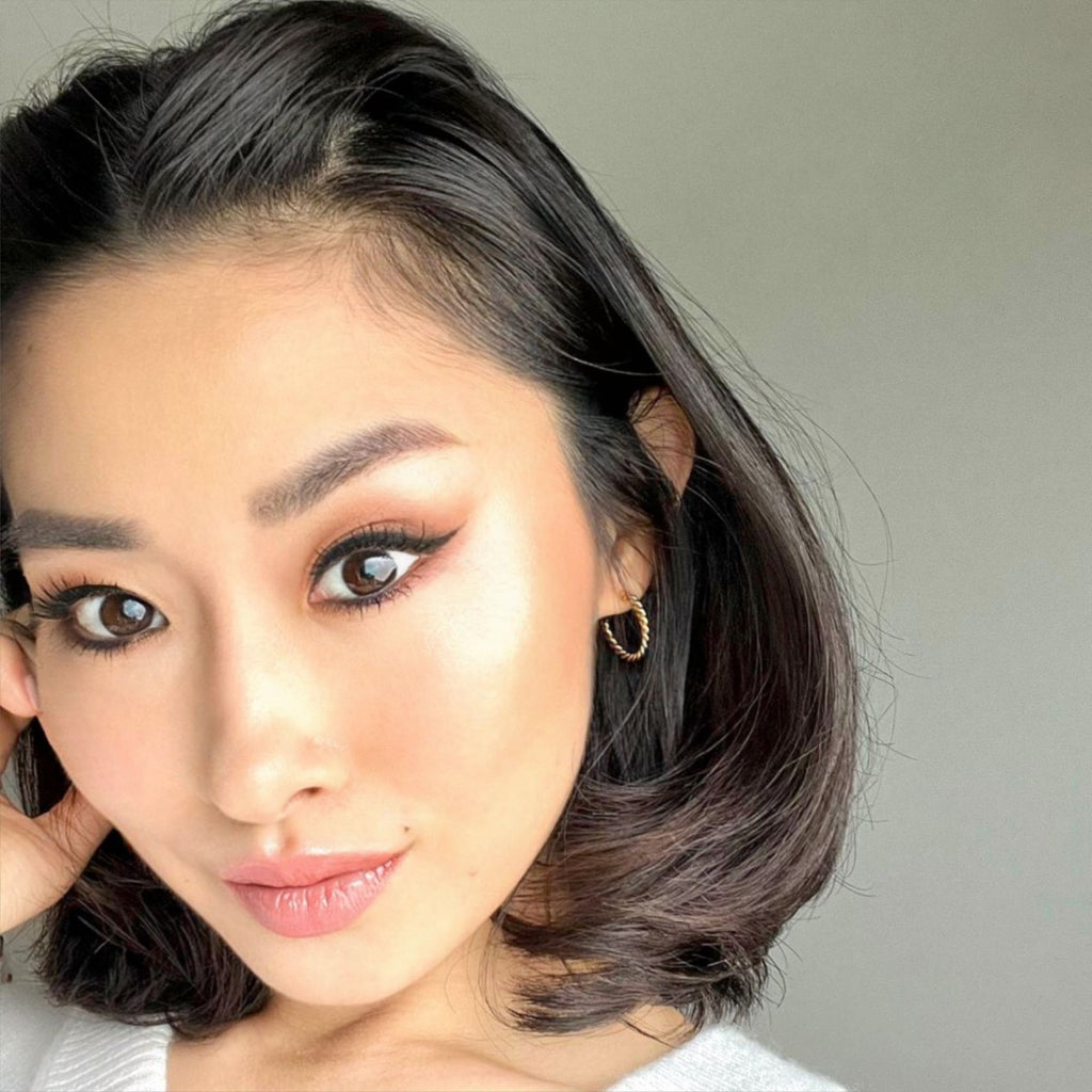 A brunette woman wearing twisted gold earrings by Misia Mae
