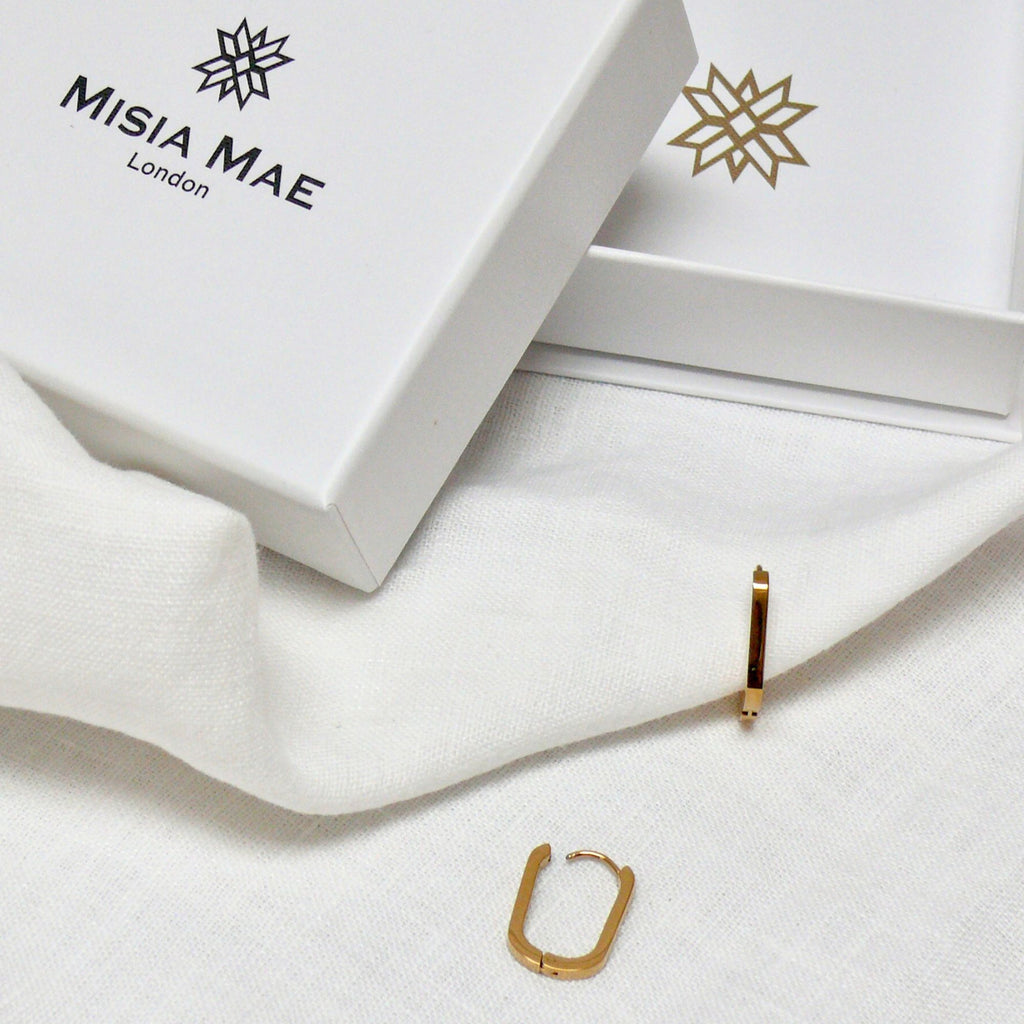 gold rectangle earrings on a white linen and Misia Mae jewellery box
