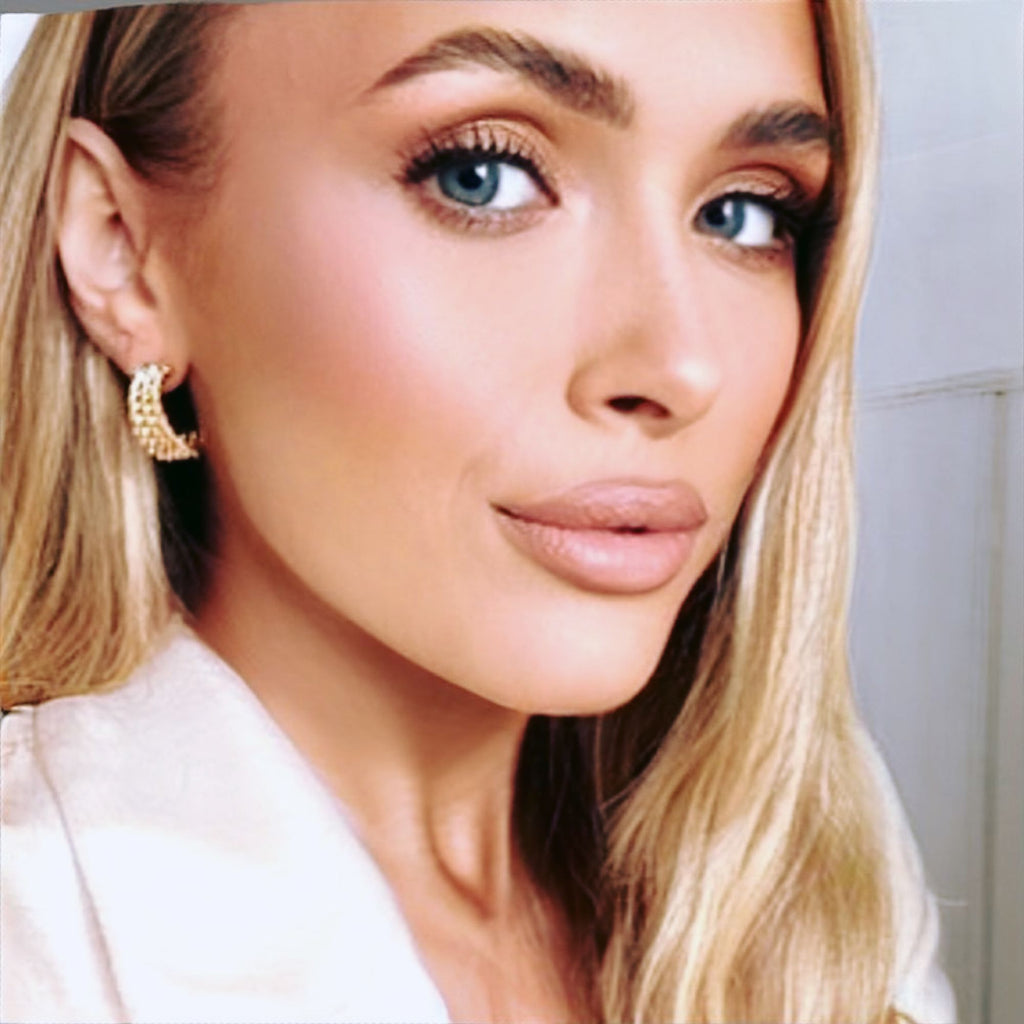 A blonde woman wearing a smart white blazer jacket and rope earrings by Misia Mae