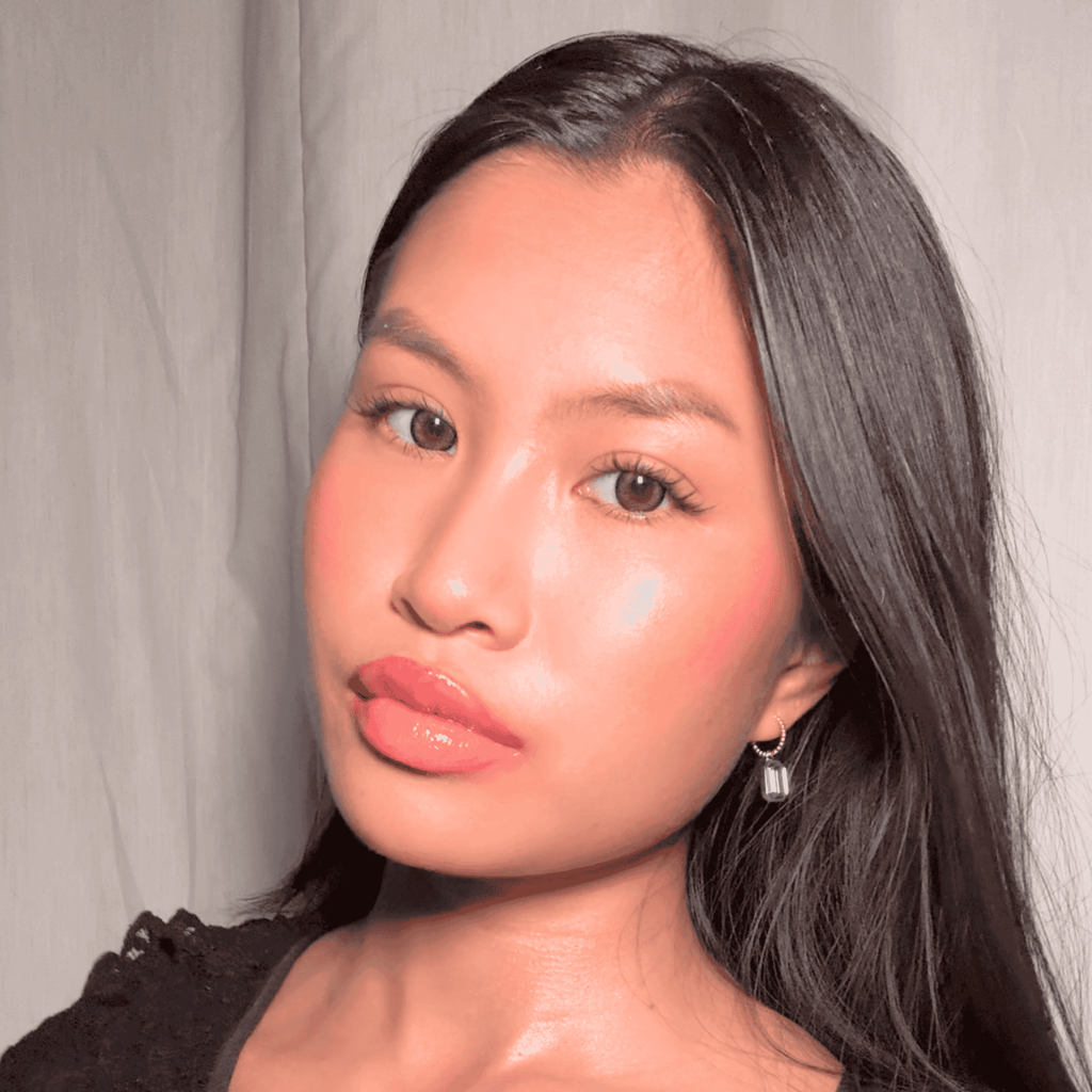 Close-up of a woman with long dark hair against a neutral background wearing Misia Mae's two tone earrings